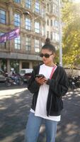 A woman is in an urban setting, using her smartphone for various daily activities video