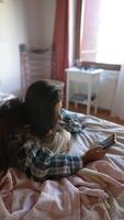 Casually relaxing on a comfortable bed with a smartphone while enjoying a laidback lifestyle video