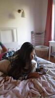 A Comfy and Relaxing Afternoon A Girl Engaged with Her Smartphone While Relaxing on Her Bed video