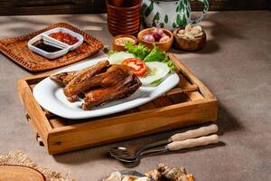 Bebek Goreng, Traditional Fried Duck. Popular Menu came from Madura, East Java. served with sambal, cucumber, tomato and lettuce. photo