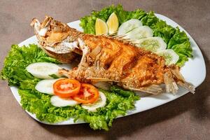 Deep fried crispy grouper fish with sambal dabu dabu photo