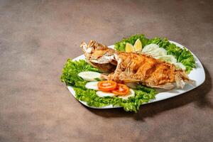 Deep fried crispy grouper fish with sambal dabu dabu photo