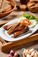 Bebek Goreng, Traditional Fried Duck. Popular Menu came from Madura, East Java. served with sambal, cucumber, tomato and lettuce. photo