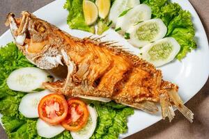 Deep fried crispy grouper fish with sambal dabu dabu photo