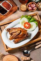 Bebek Goreng, Traditional Fried Duck. Popular Menu came from Madura, East Java. served with sambal, cucumber, tomato and lettuce. photo