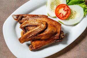 Bebek Goreng, Traditional Fried Duck. Popular Menu came from Madura, East Java. served with sambal, cucumber, tomato and lettuce. photo