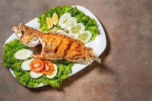 Deep fried crispy grouper fish with sambal dabu dabu photo