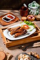 Bebek Goreng, Traditional Fried Duck. Popular Menu came from Madura, East Java. served with sambal, cucumber, tomato and lettuce. photo