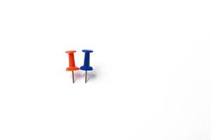 two different colorful push pins on white background photo