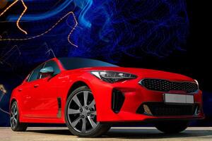 Red car on a black background. Stylish, modern, bright image of the car for design solutions. photo