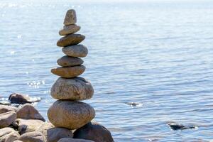 Pyramid of stones. Unstable balance of stone objects. Idyllic state of nature. photo