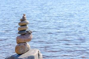 Pyramid of stones. Unstable balance of stone objects. Idyllic state of nature. photo