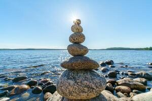 Pyramid of stones. Unstable balance of stone objects. Idyllic state of nature. photo