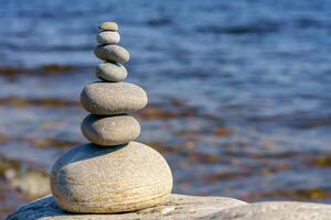 Pyramid of stones. Unstable balance of stone objects. Idyllic state of nature. photo