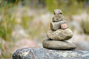 Pyramid of stones. Unstable balance of stone objects. Idyllic state of nature. photo