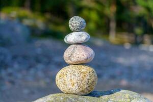Pyramid of stones. Unstable balance of stone objects. Idyllic state of nature. photo