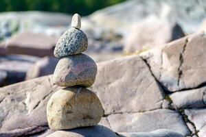 Pyramid of stones. Unstable balance of stone objects. Idyllic state of nature. photo