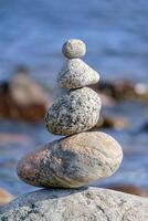 Pyramid of stones. Unstable balance of stone objects. Idyllic state of nature. photo