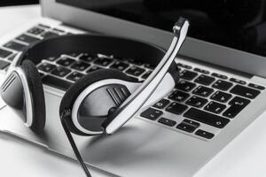 call center support concept. headset on keyboard computer laptop photo