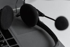 call center support concept. headset on keyboard computer laptop photo