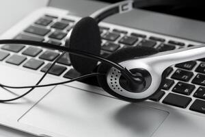 call center support concept. headset on keyboard computer laptop photo