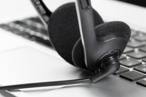 call center support concept. headset on keyboard computer laptop photo