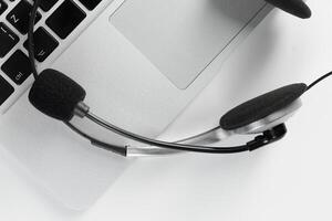 call center support concept. headset on keyboard computer laptop photo
