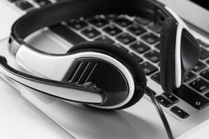 call center support concept. headset on keyboard computer laptop photo