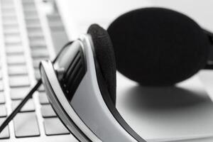 call center support concept. headset on keyboard computer laptop photo