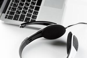 call center support concept. headset on keyboard computer laptop photo