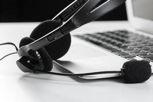 call center support concept. headset on keyboard computer laptop photo