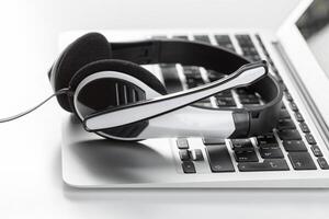 call center support concept. headset on keyboard computer laptop photo