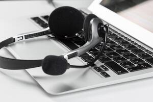 call center support concept. headset on keyboard computer laptop photo
