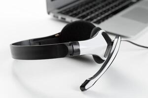 call center support concept. headset on keyboard computer laptop photo