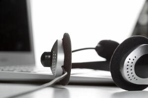 call center support concept. headset on keyboard computer laptop photo