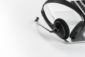 call center support concept. headset on keyboard computer laptop photo