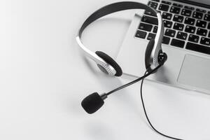 call center support concept. headset on keyboard computer laptop photo