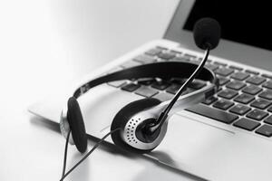 call center support concept. headset on keyboard computer laptop photo