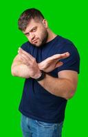 A man with a dense beard and strong build gestures confidently against a bright green background photo