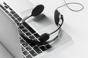 call center support concept. headset on keyboard computer laptop photo