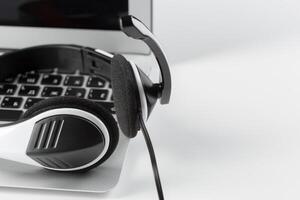 call center support concept. headset on keyboard computer laptop photo