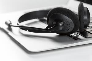 call center support concept. headset on keyboard computer laptop photo
