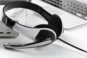 call center support concept. headset on keyboard computer laptop photo