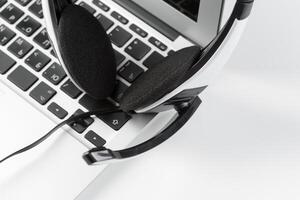 call center support concept. headset on keyboard computer laptop photo