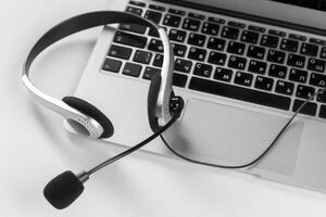 call center support concept. headset on keyboard computer laptop photo