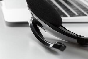 call center support concept. headset on keyboard computer laptop photo