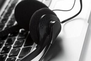 call center support concept. headset on keyboard computer laptop photo