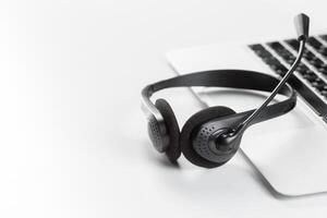 call center support concept. headset on keyboard computer laptop photo