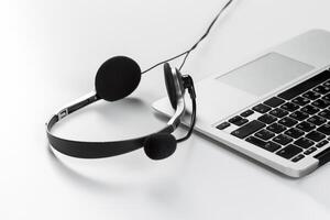 call center support concept. headset on keyboard computer laptop photo