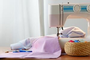 Sewing machine in use on a wooden table, stitching a light fabric in a well-lit indoor workspace photo